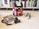 A vibrant, rugged backpack resting on a school desk with books and a laptop nearby.
