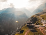 person paragliding on mountain cliff during daytime