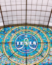 A shadowed silhouette of Nikola Tesla with glowing purple and gold accents.