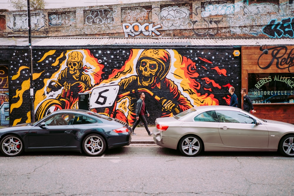 two brown and black vehicles parked near Rebels alliance motorcycle painted wall