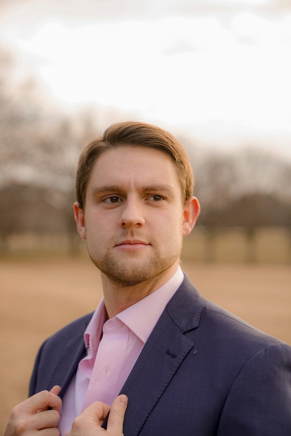 man wearing inner dress shirt with black blazer standing outside at daytime