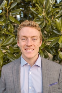 man in grey blazer near green trees during daytime