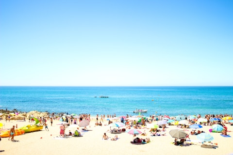 seashore with crowding people under blue sky
