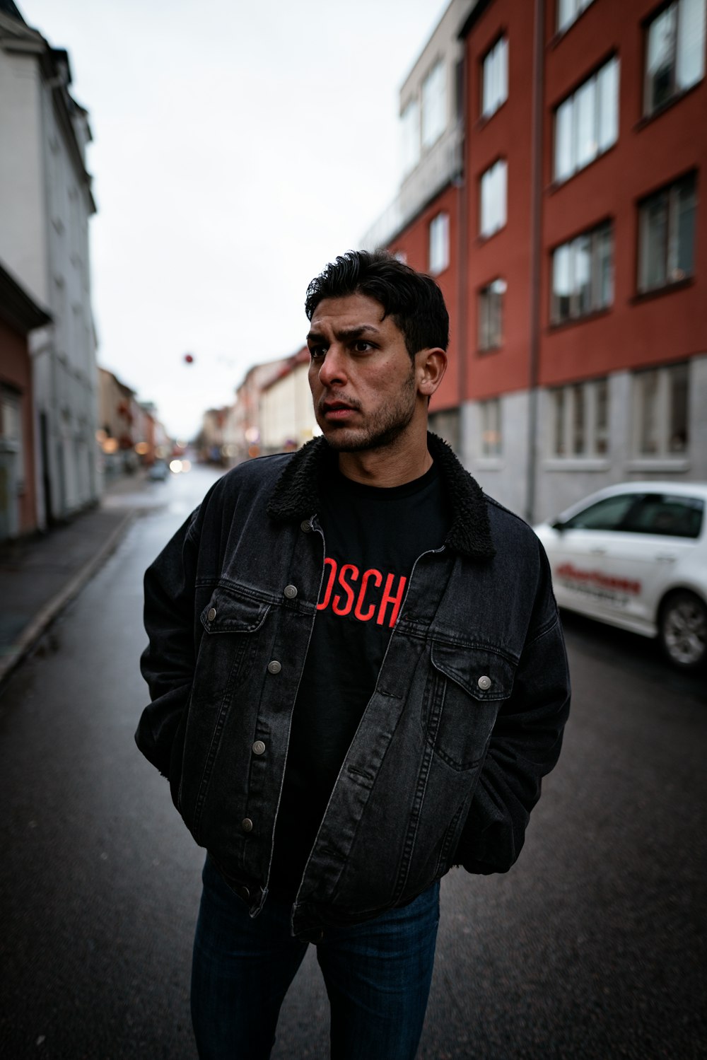 man in black jacket standing on the road