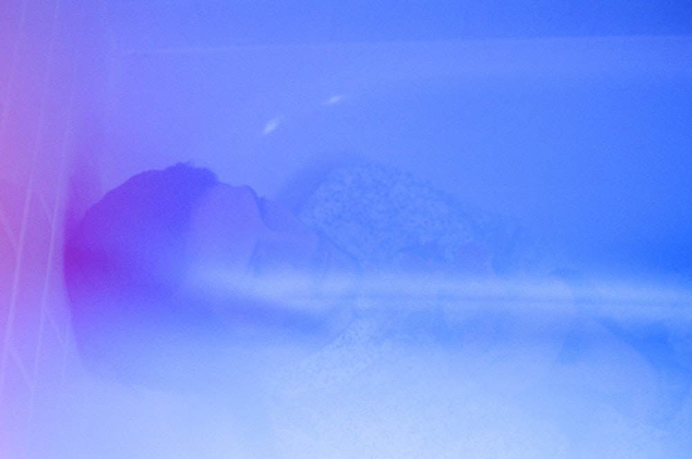 man in grey shirt lying on bathtub