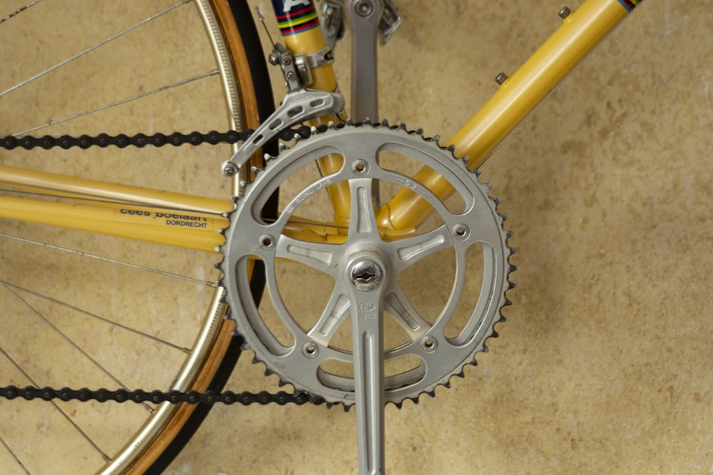 グレーのペダルスプロケット付き黄色の自転車
