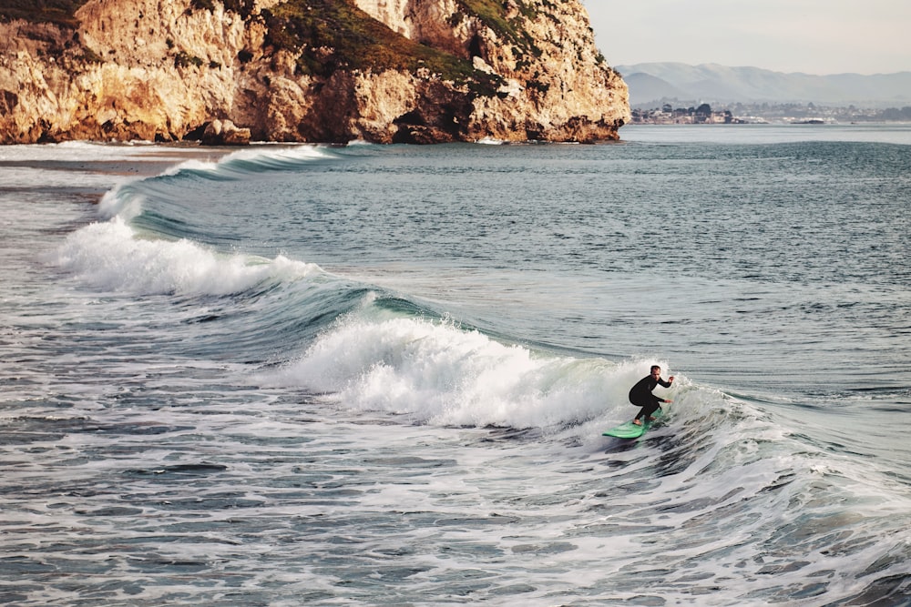 man surfing on sea wave during daytime