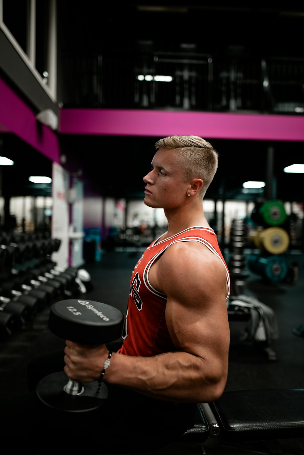 man standing while holding dumbbell inside gym