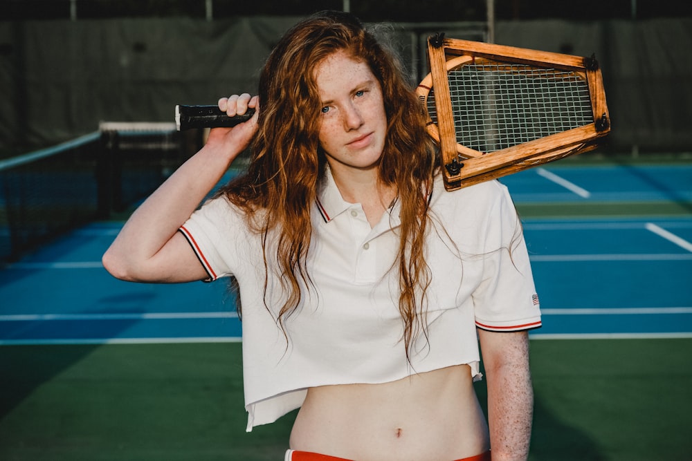woman holds vintage tennis rackets