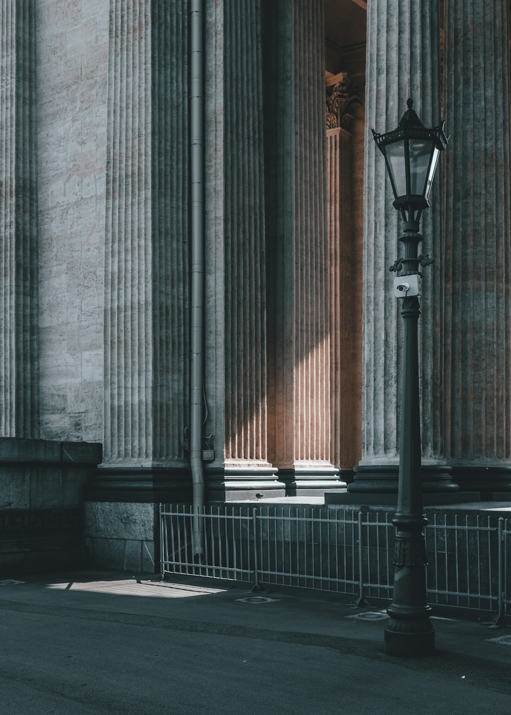 grayscale photo of street lamp beside building