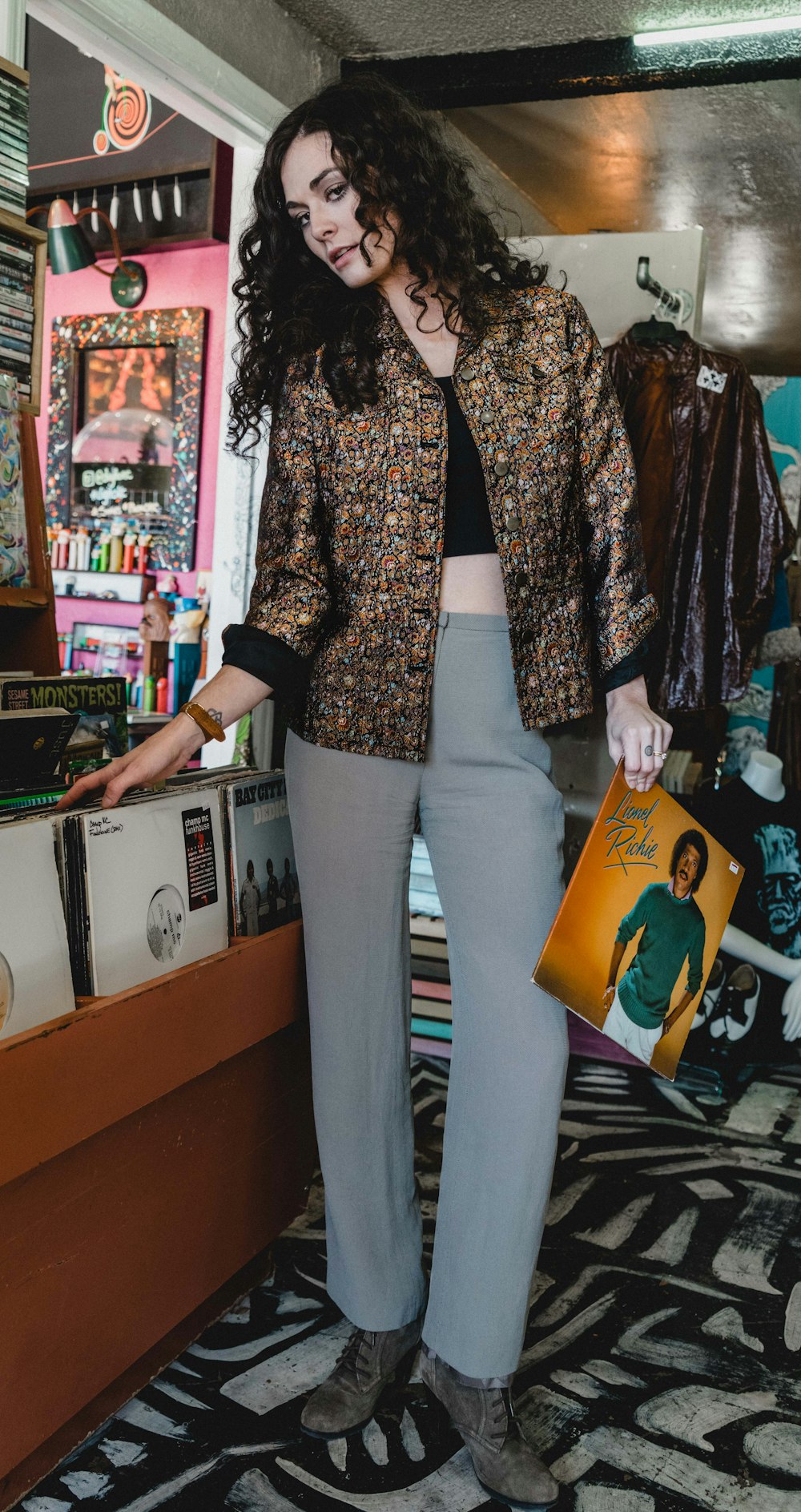 woman holding record sleeve inside store