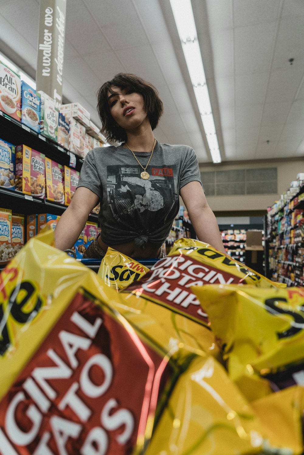 mulher em pé na frente de sacos de chip dentro da loja