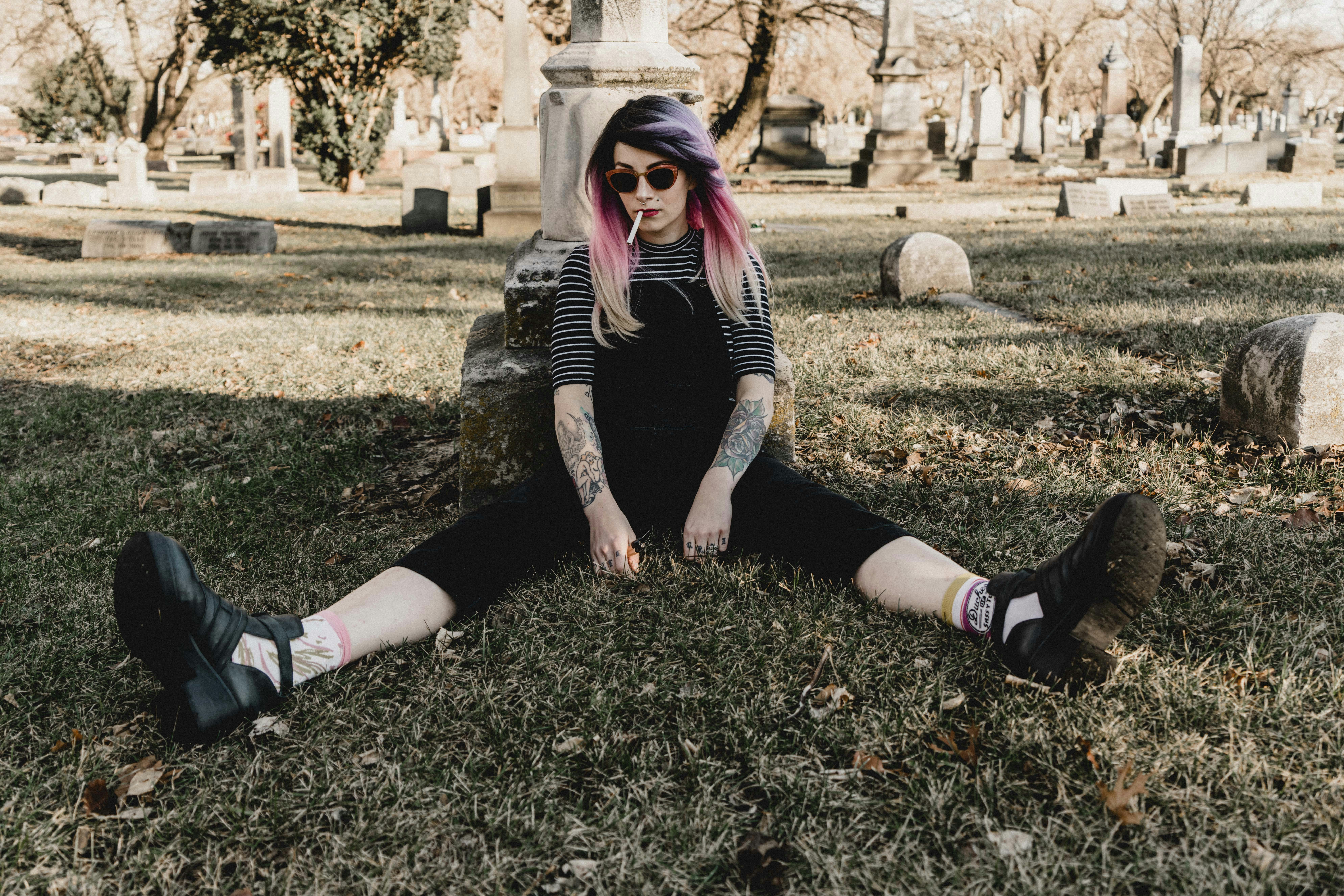 woman sitting on grass with legs separated surrounded with trees