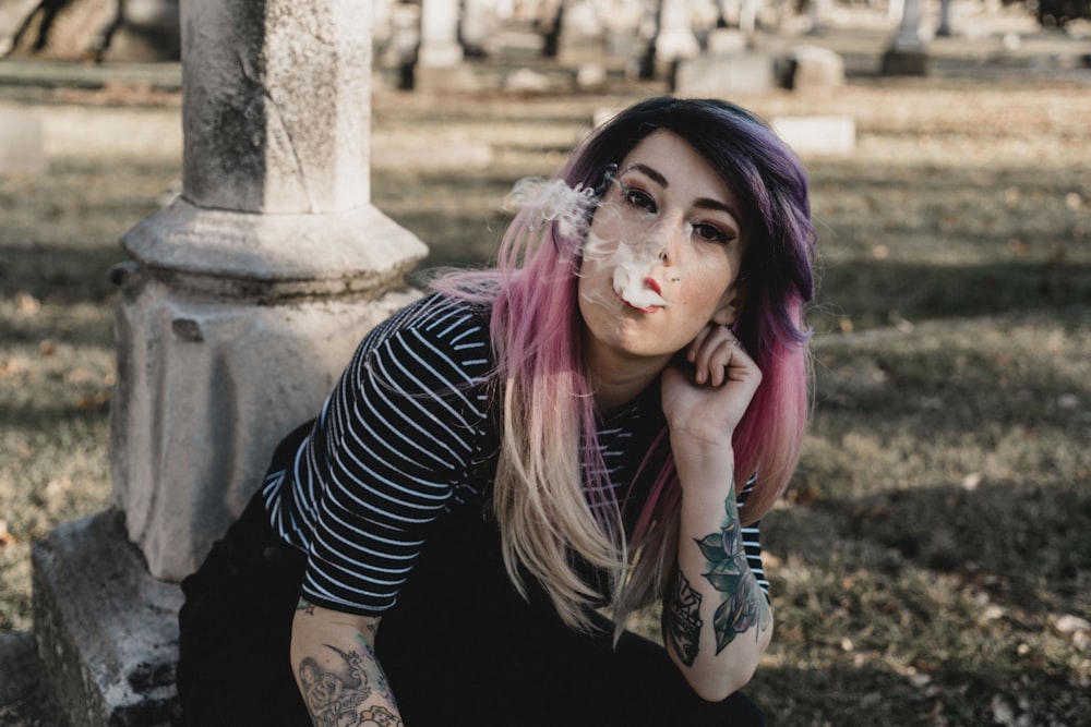 woman smoking wearing black and white striped shirt