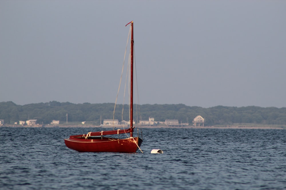 barca di legno rossa sul mare durante il giorno