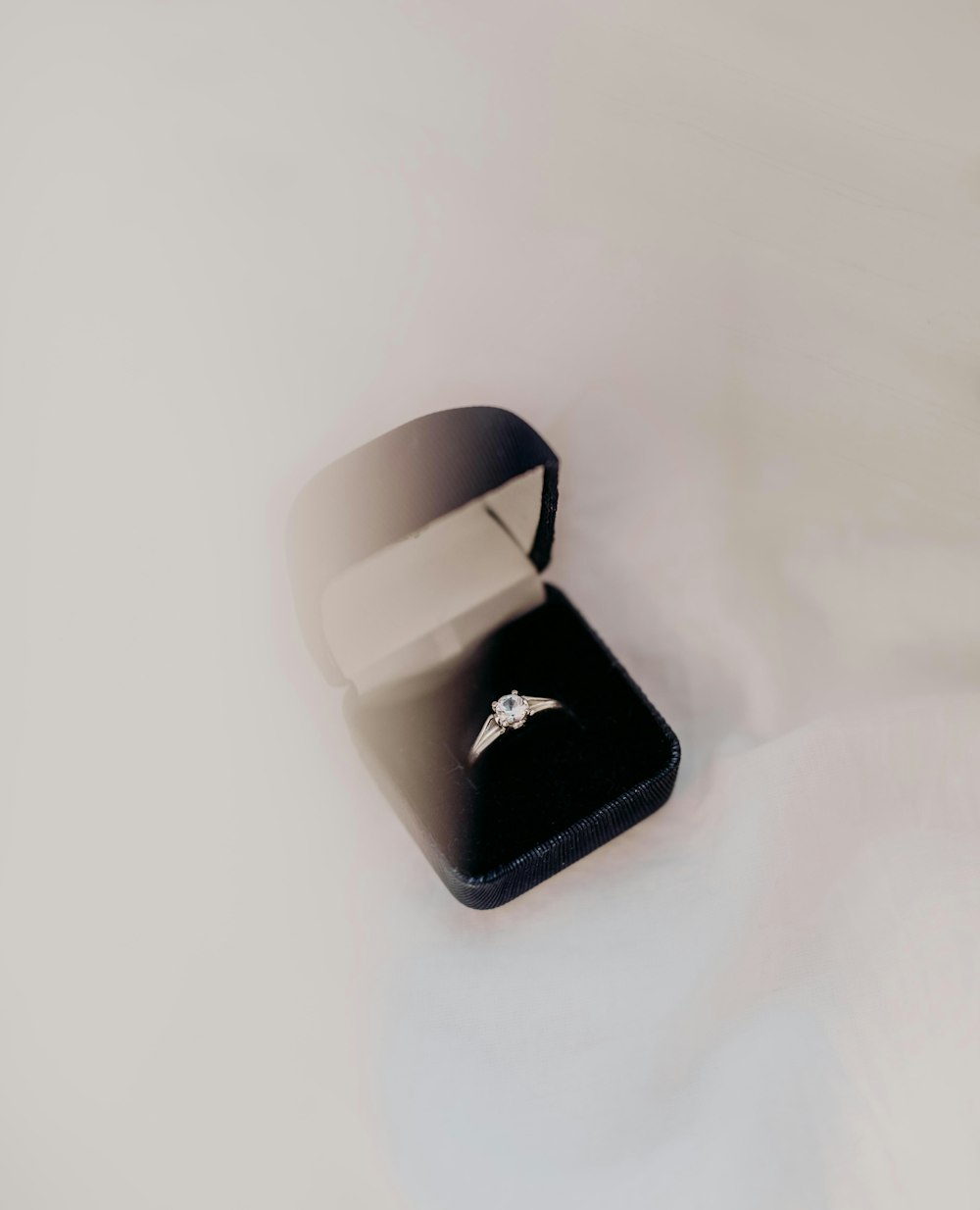 silver engagement ring on black box
