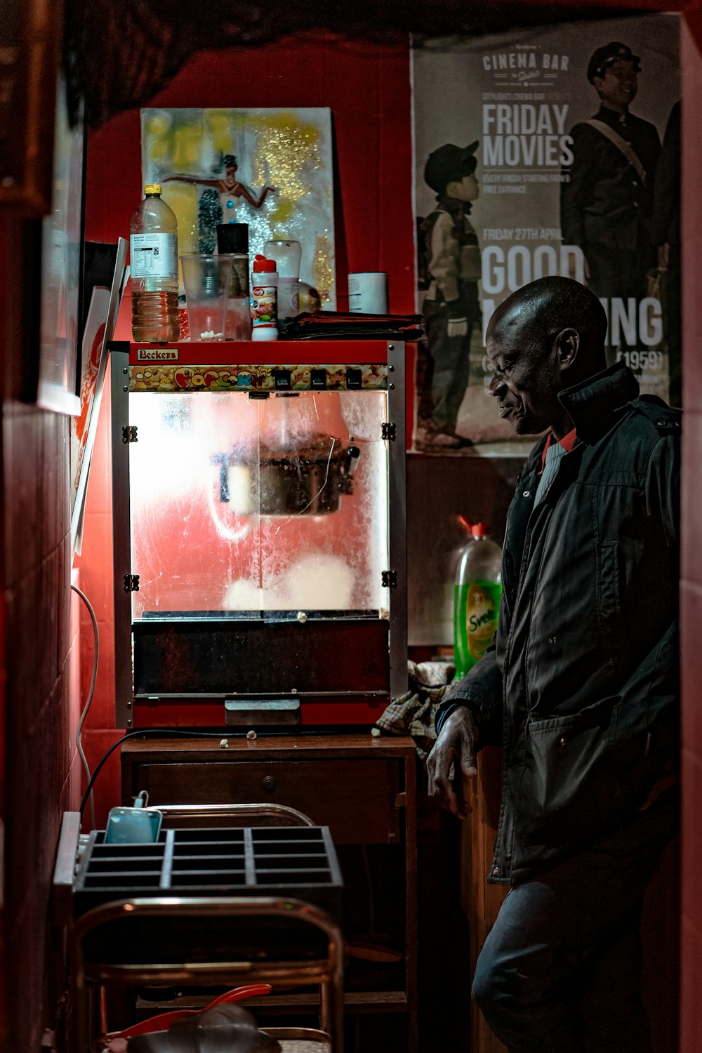 man standing beside popcorn maker