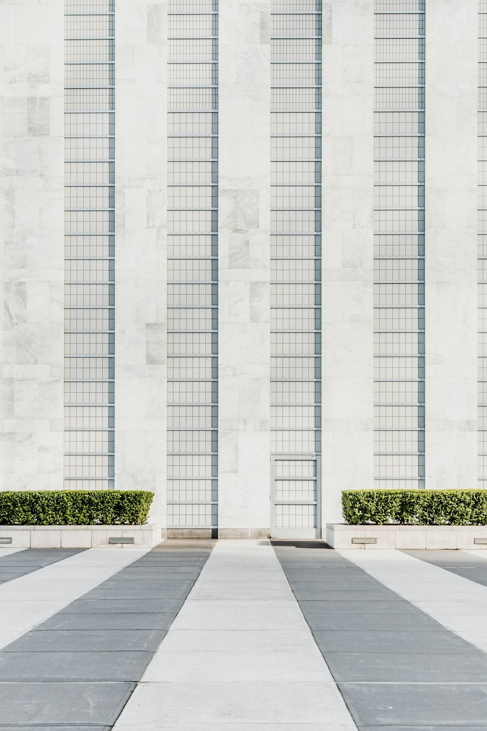 edificio in cemento bianco vicino a cespugli verdi