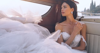woman wearing white sweetheart-neckline wedding dress inside vehicle