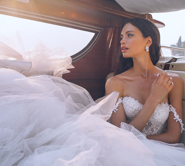 woman wearing white sweetheart-neckline wedding dress inside vehicle