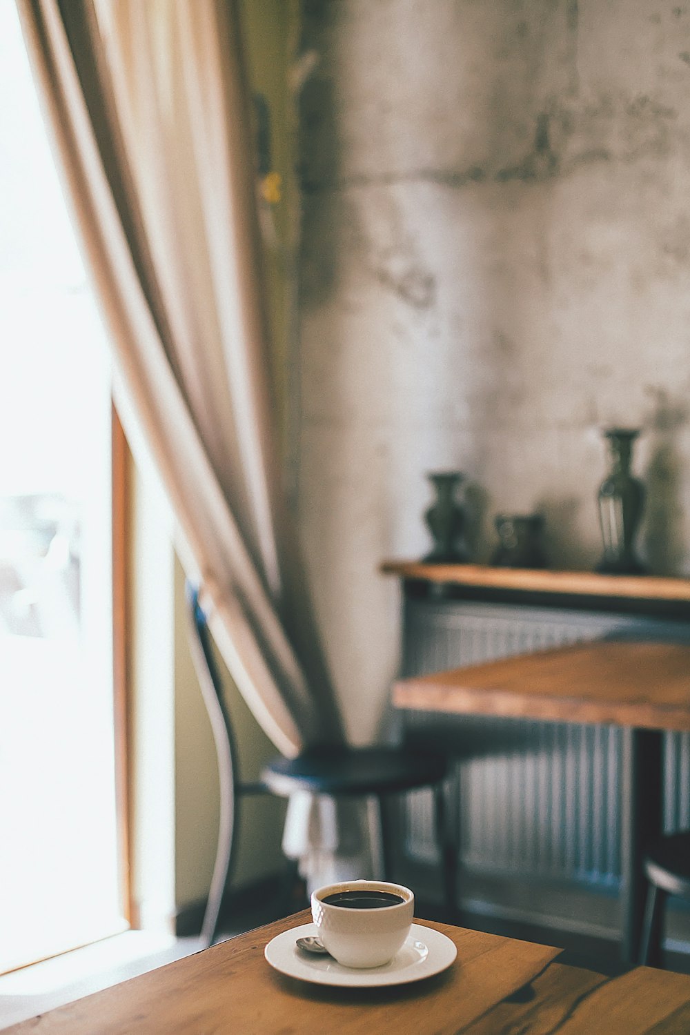 black coffee inside teacup on brown wooden table