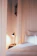 A cozy bedroom scene with a Melara pillow resting on a neatly made bed.