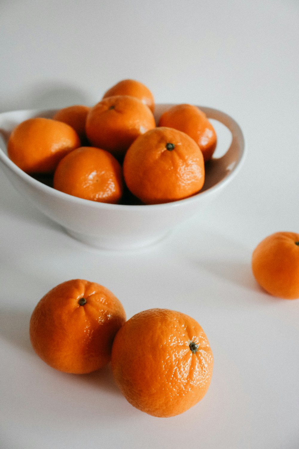 orangefarbene Früchte auf weißer Schale