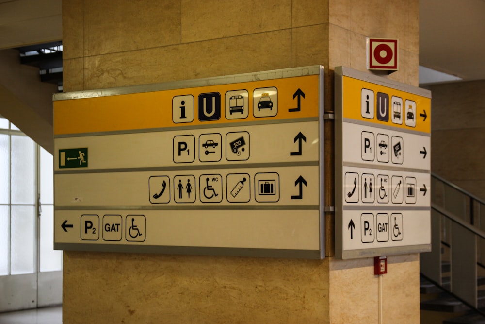 white and yellow signage on concrete post