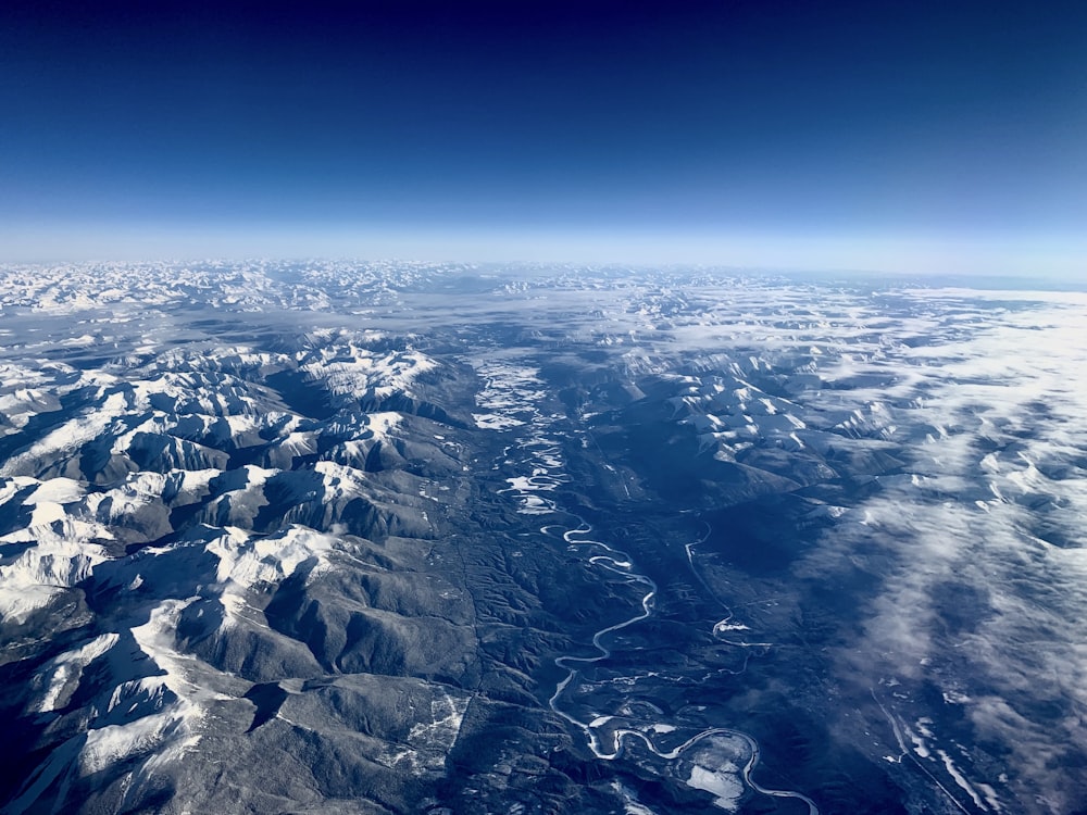 aerial photography of winding road surrounded by fault block mountain with ice cap