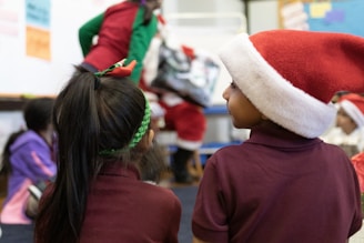 A joyful classroom filled with children writing letters to Santa.