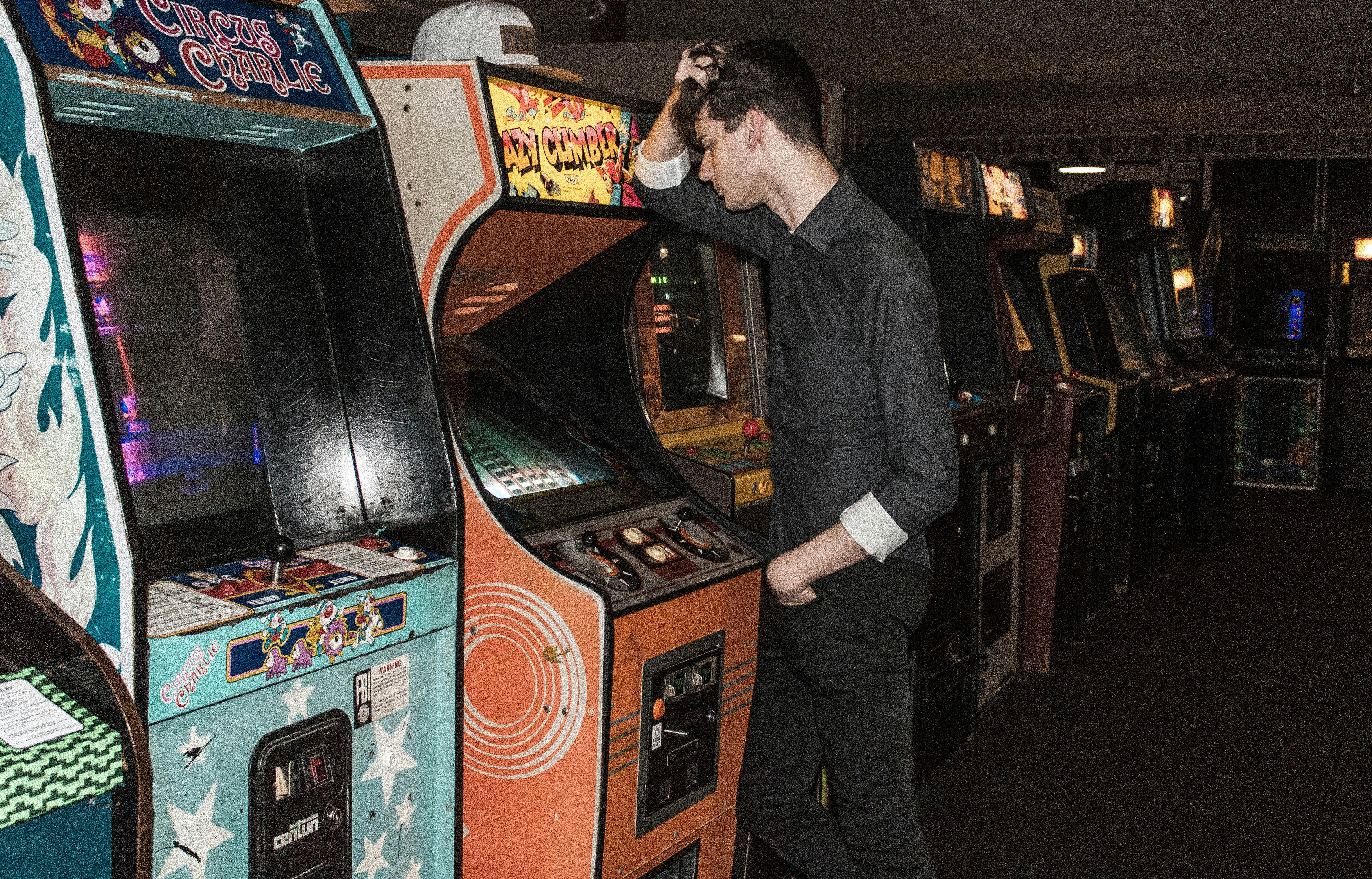man standing in front of arcade machine, 