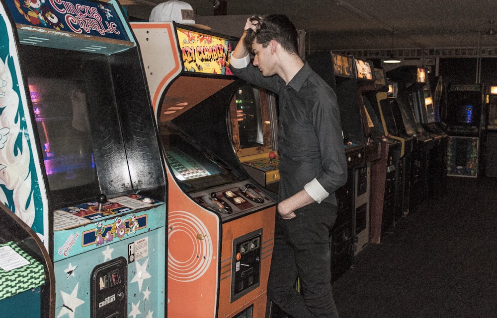 man standing in front of arcade machine