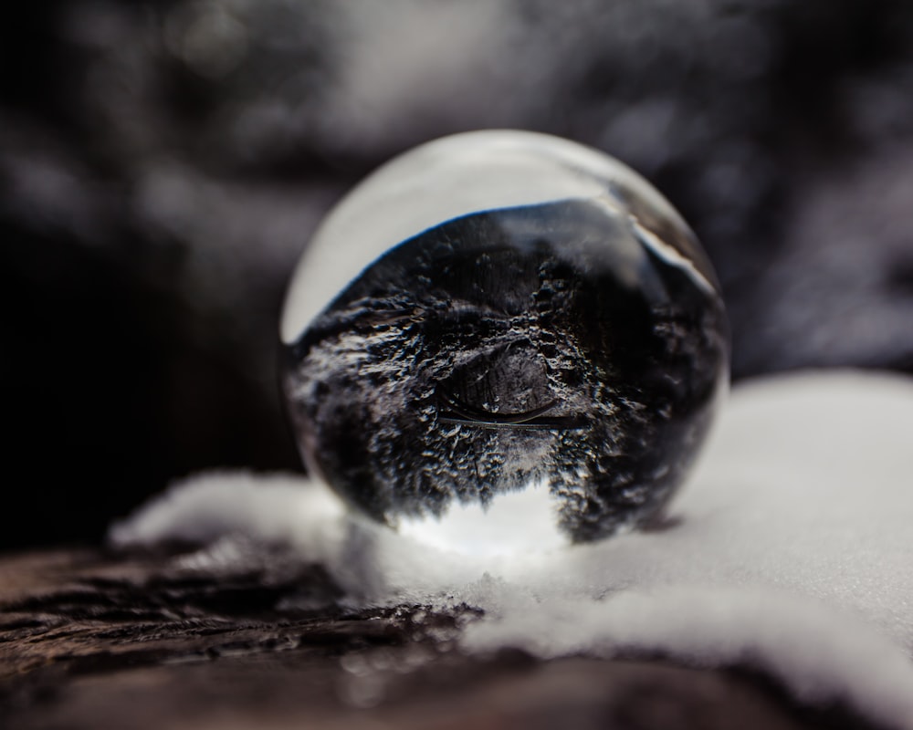 round clear glass ball on white textile