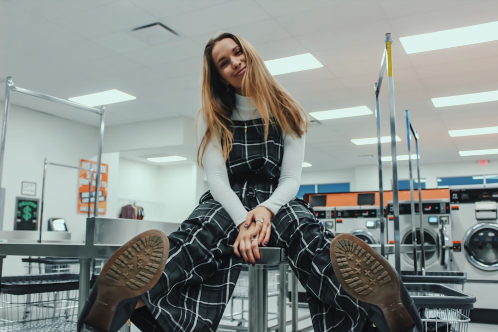 woman sitting near washer clothes