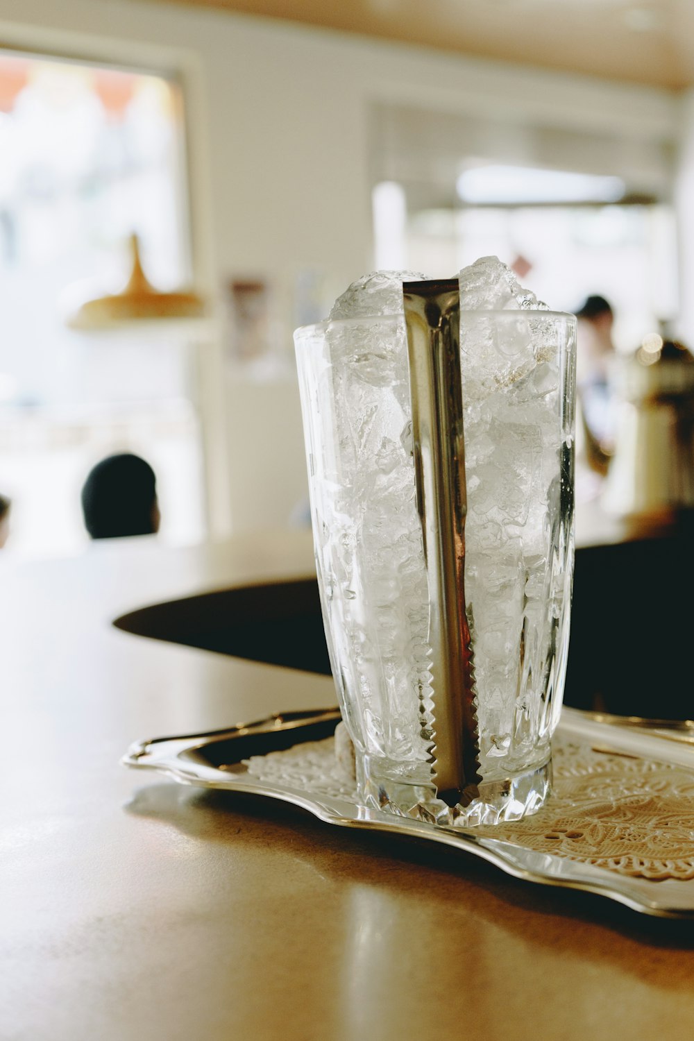 얼음과 얼음 집게로 채워진 투명한 음료수 잔