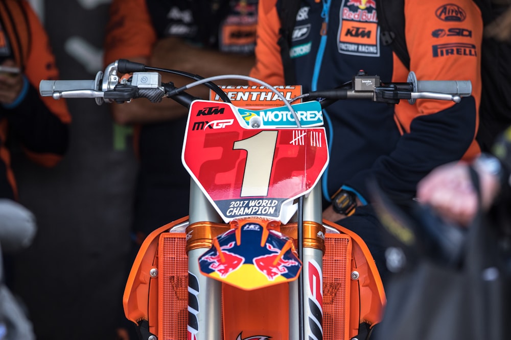 shallow focus photo of orange motocross dirt bike