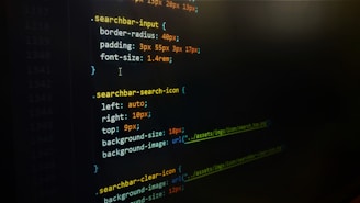 A screenshot of CSS code on a dark background, featuring styling rules for search bar elements such as border-radius, padding, and font size. Colored highlights emphasize syntax, with properties and values outlined in purple, orange, and green.