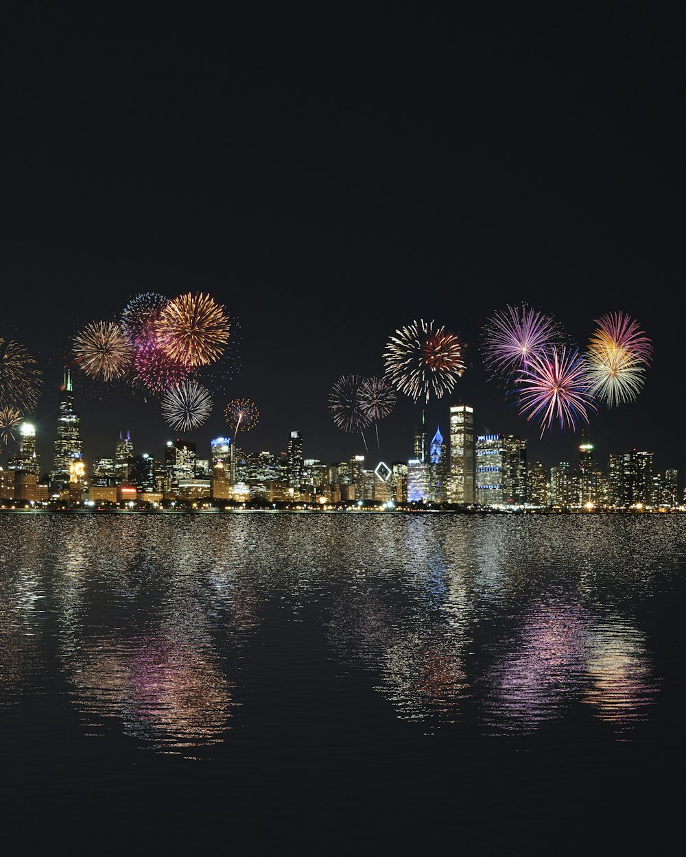 Edificios del horizonte bajo la exhibición de fuegos artificiales