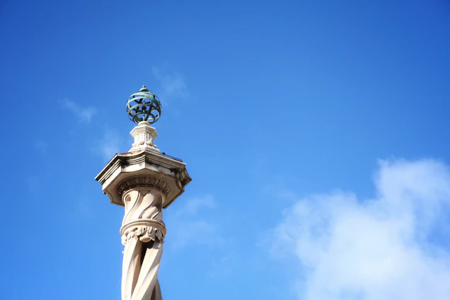 A sturdy pillar standing tall against a clear blue sky, symbolizing strength and stability.