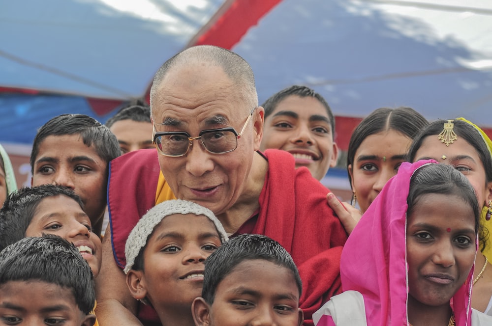 man in black framed eyeglasses surrounded with children