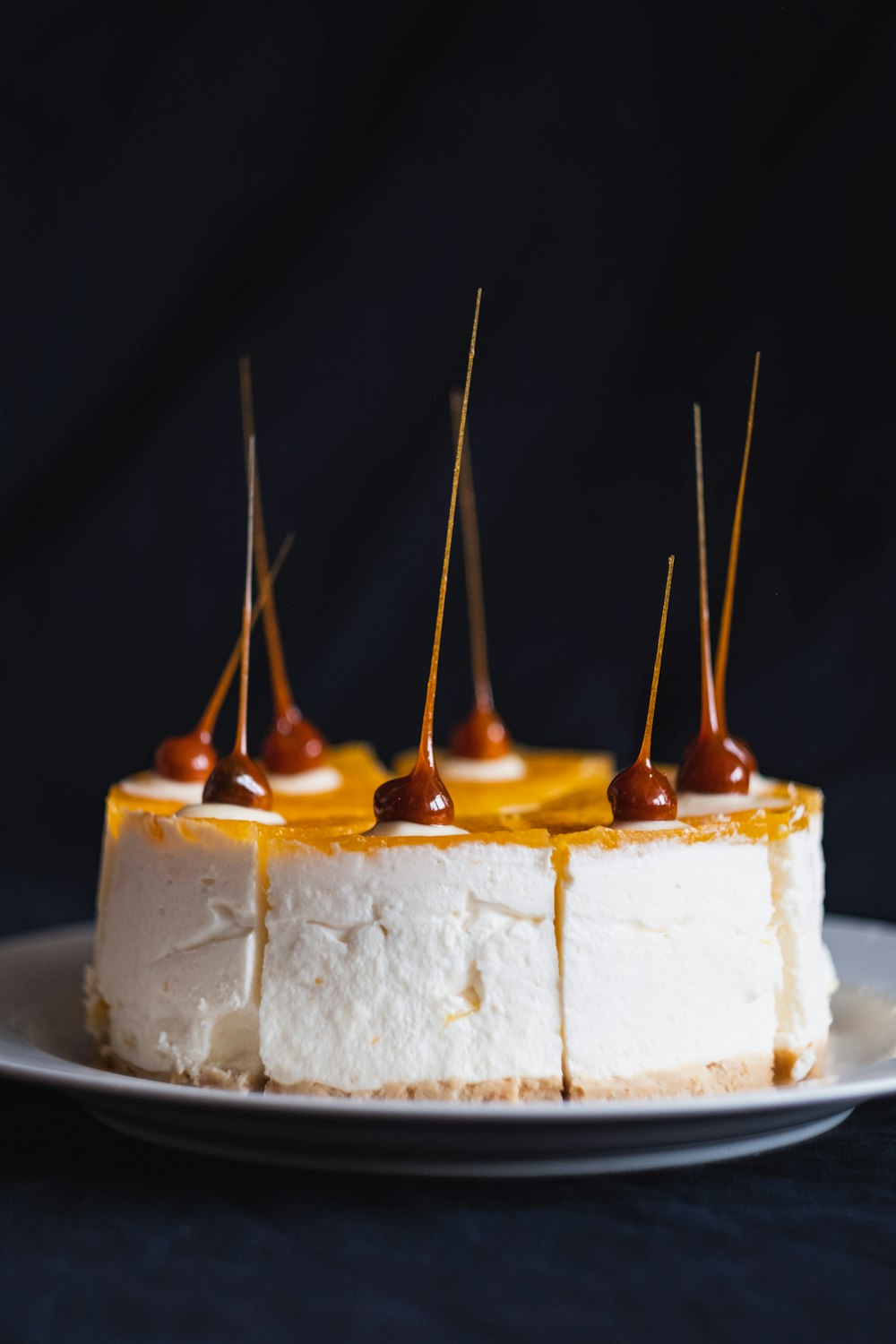 selective focus photography of cheery topped cake on white plate