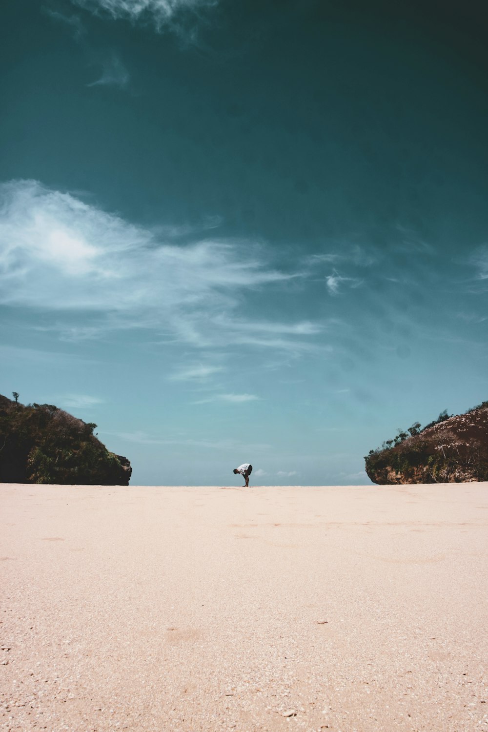 man bend his body in the middle of two islands