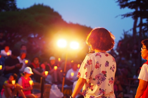 A peaceful gathering with individuals holding candles at night.