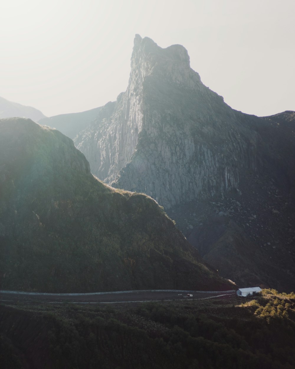 vehicle running on road beside mountain