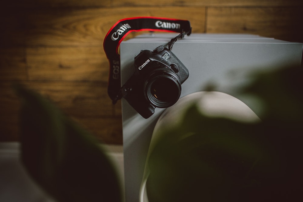 schwarze Canon DSLR-Kamera auf weißer Tafel