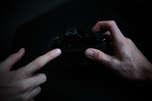 An intimate close-up of hands working with film, bathed in soft cinematic lighting.
