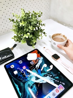 A stylish workspace with a tablet, coffee cup, and shopping catalog spread out