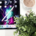 A vibrant digital habit tracker on a tablet screen surrounded by notes and a pen.