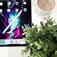 A modern tablet displaying vibrant colors, placed beside a cozy coffee cup on a minimalist desk.