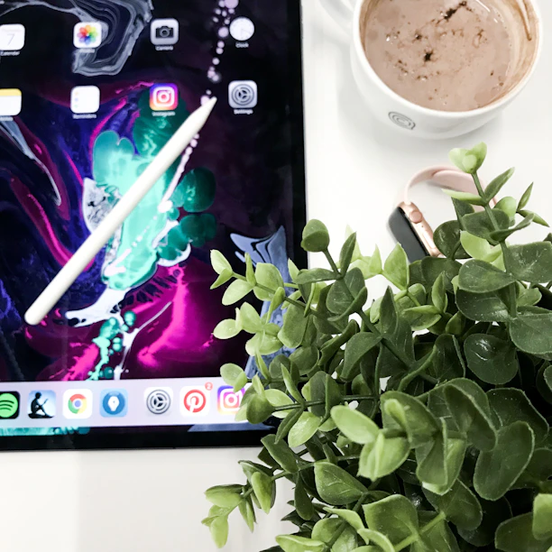 A vibrant tablet displaying colorful graphics resting on a cozy couch beside a cup of coffee.